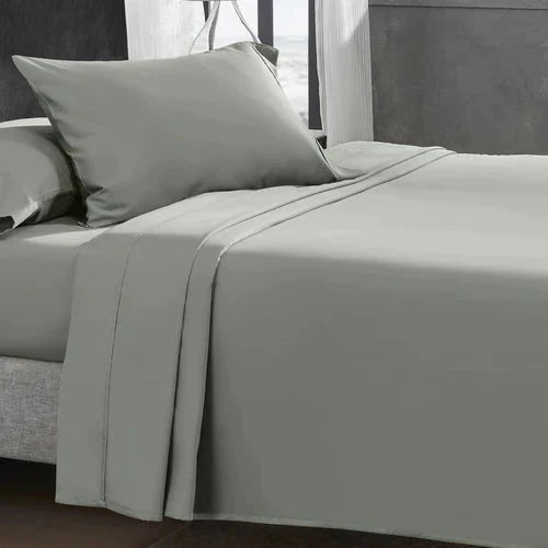 "CinchFit King Sheets in sage green on a made bed. 400TC cotton with 15-inch depth for a smooth, hotel-quality finish."